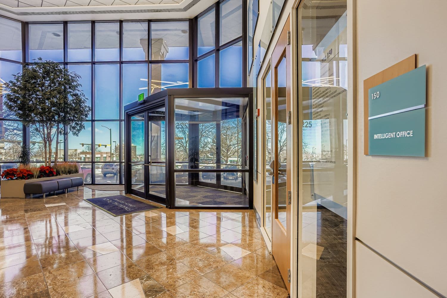 Modern office entrance with glass doors, interior lobby, and Intelligent Office signage.