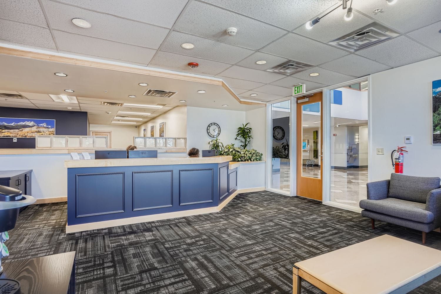 Modern office reception area with blue accents and seating, ideal for professional business environments.