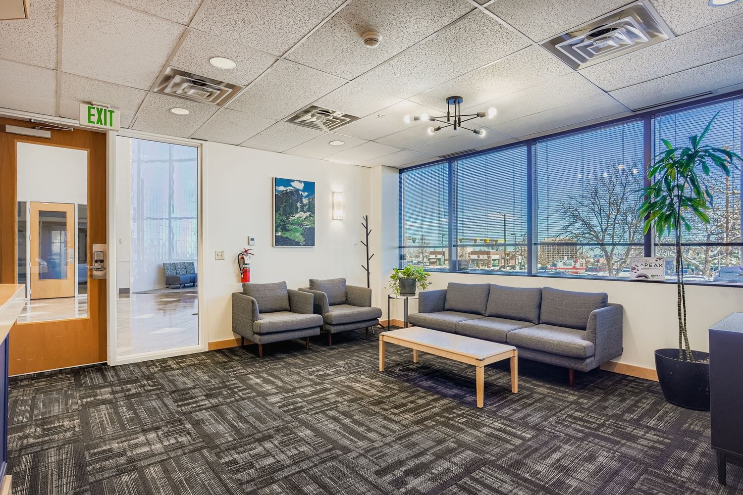 Bright professional coworking space with modern furniture and large windows, ideal for business meetings and private work.