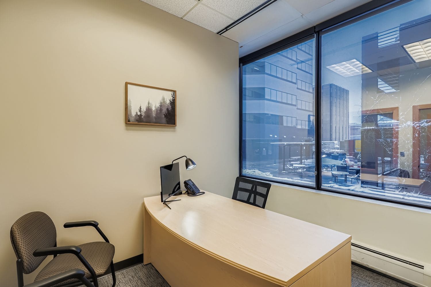 Comfortable office chair and desk with computer in modern coworking space, natural lighting.