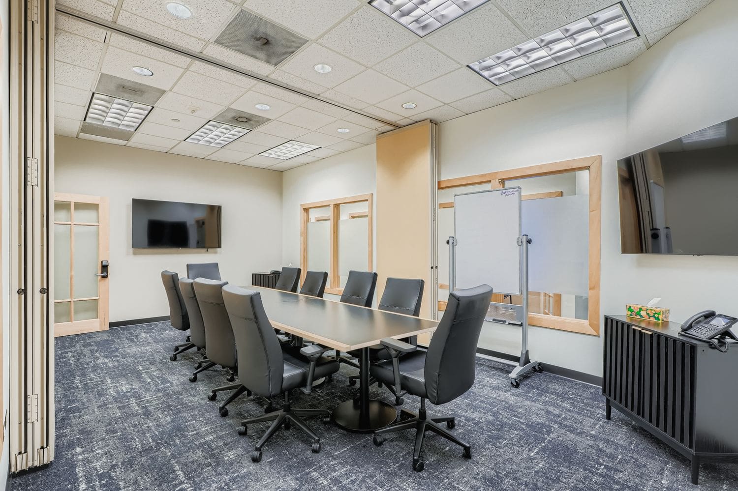 Modern office meeting room with conference table and black chairs, coworking space at Intelligent Office.