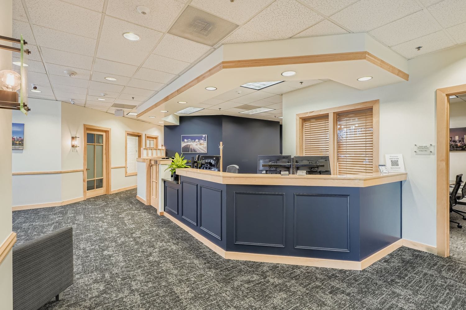 Modern office reception area with desk, computers, and welcoming decor for professional workspace.