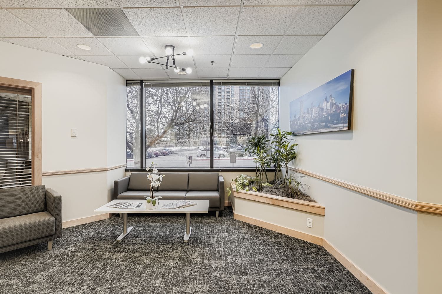 Modern business office waiting area with comfortable seating and large windows.