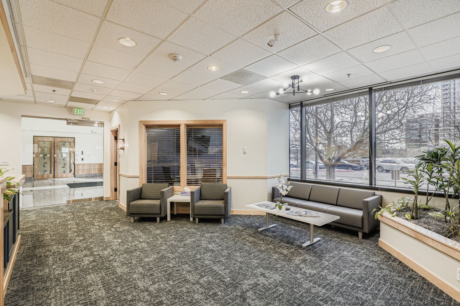 Comfortable corporate reception area with modern furniture and large windows, ideal for professional business environments.