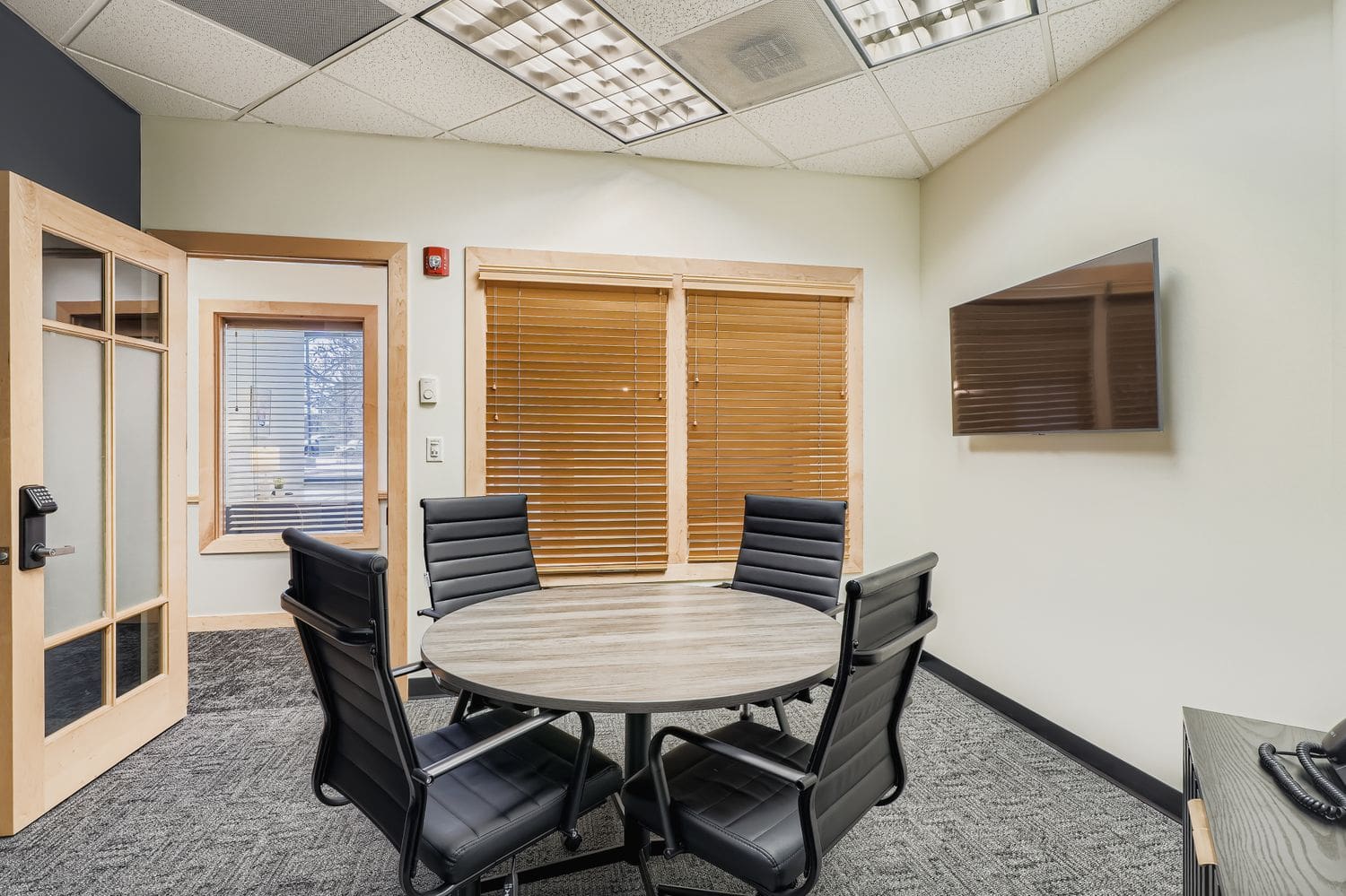 Modern office meeting room with conference table and chairs, ideal for professional workspace needs.