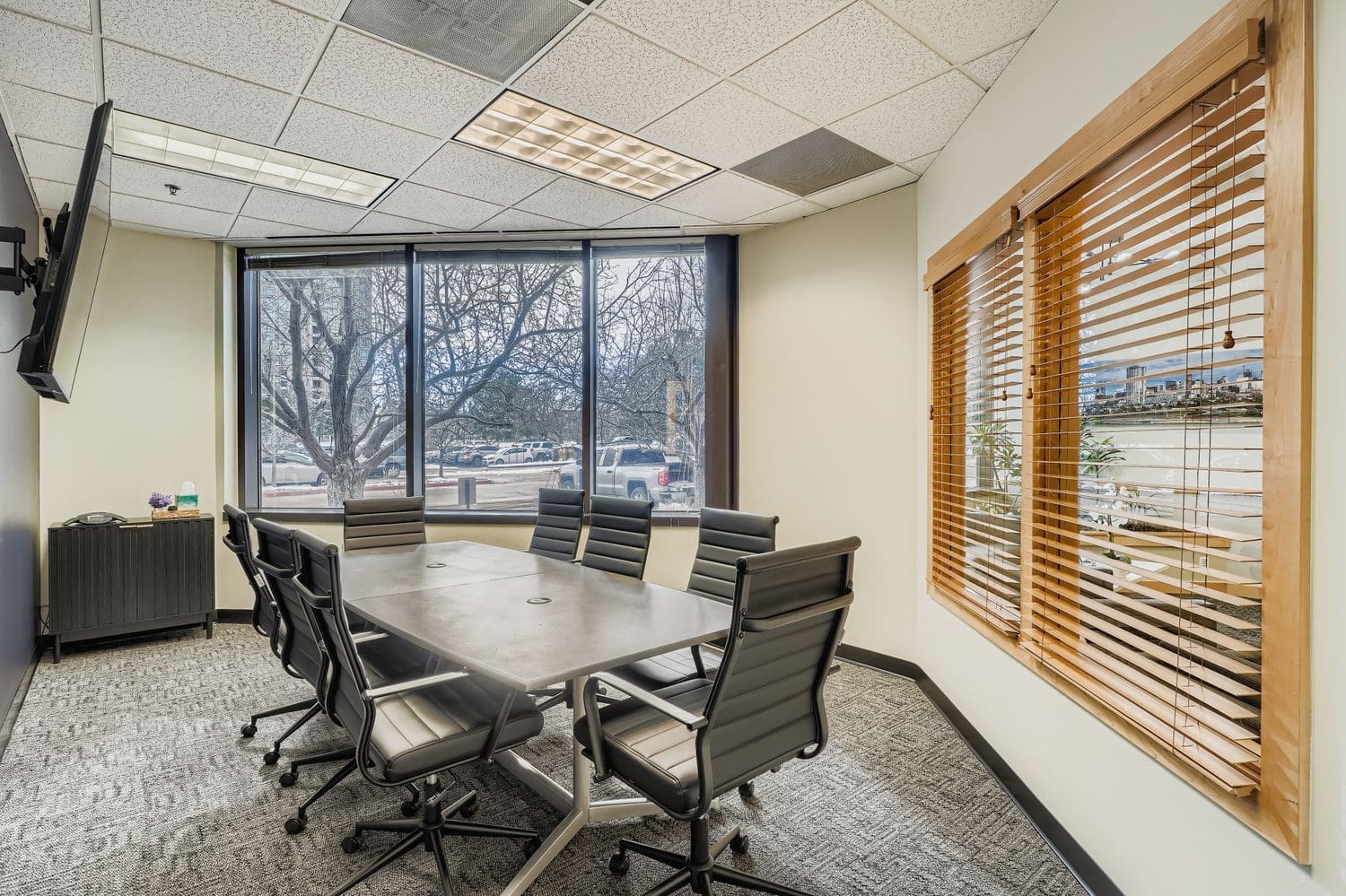 Modern conference room with large windows and professional workspace furniture for business meetings.