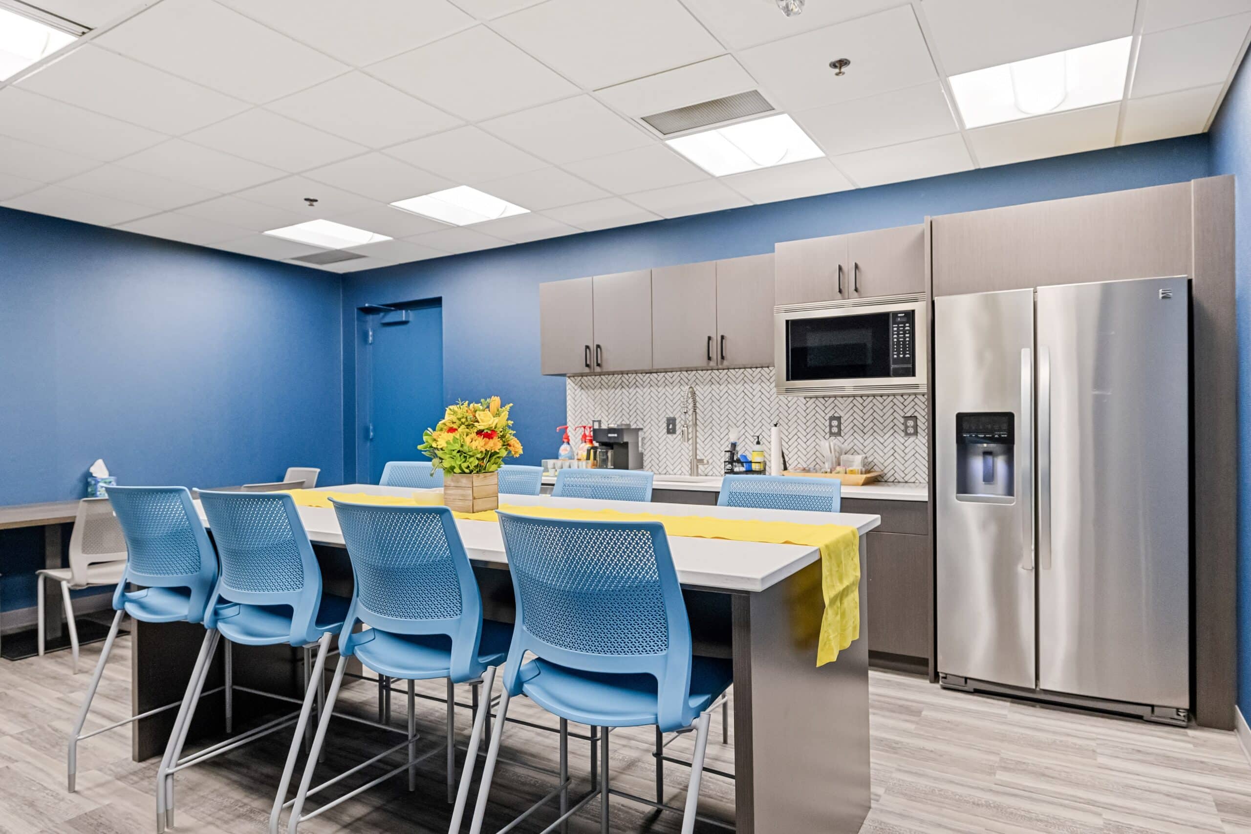 Flexible office kitchen with modern appliances and seating area at Intelligent Office Troy.