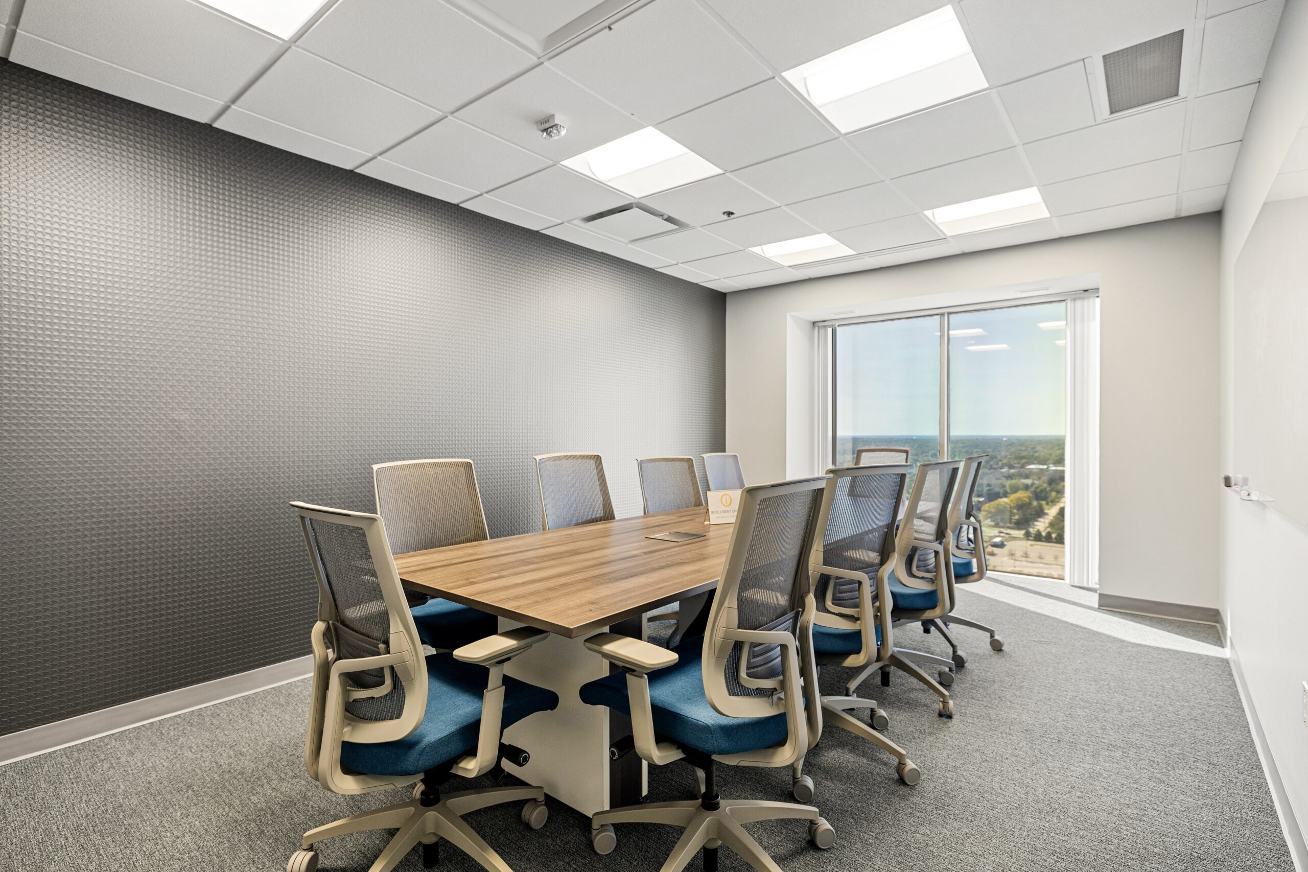 Modern office conference room with ergonomic chairs and large window, ideal for meetings and collabo.