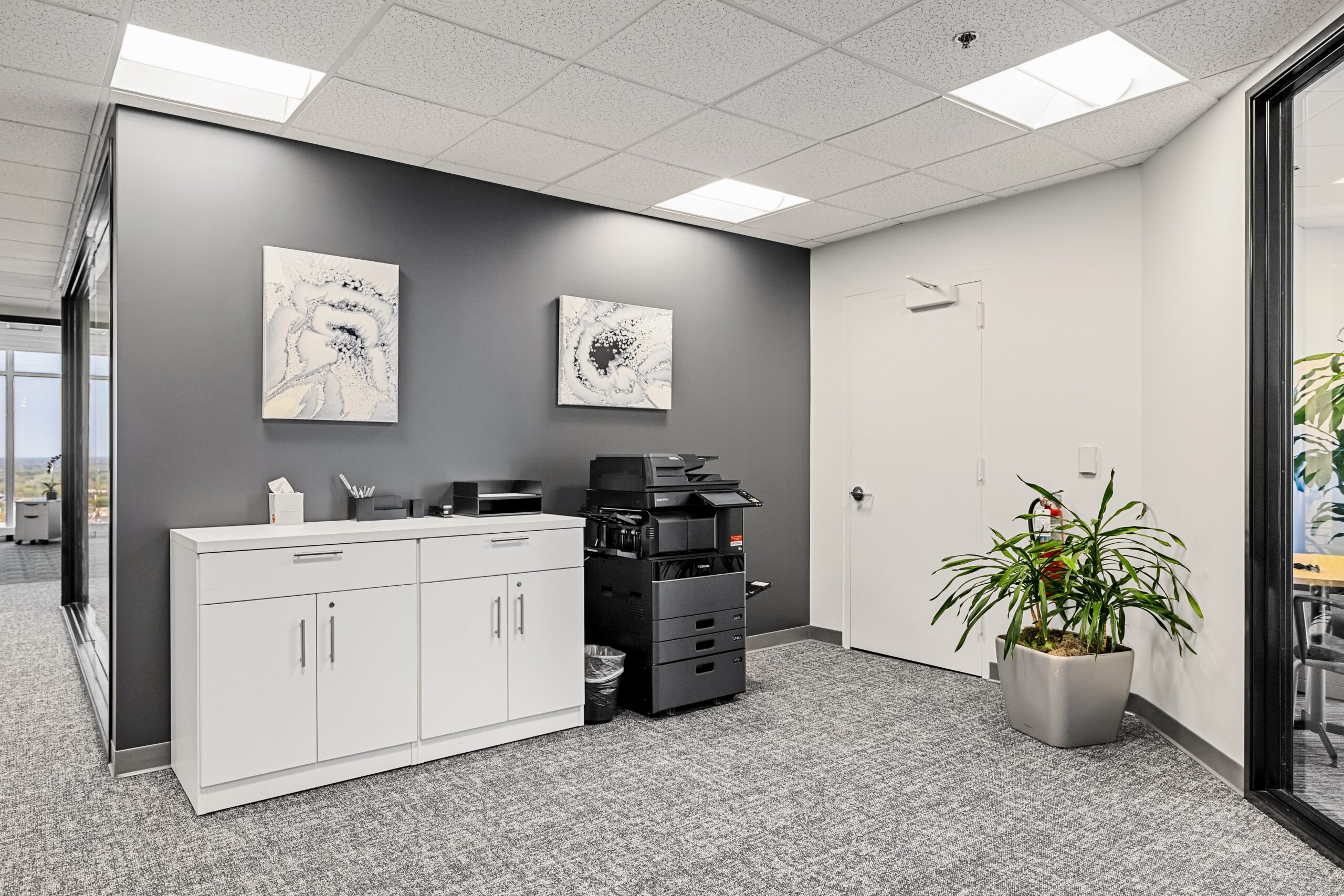 Flexible office space with modern decor and a printer in Troy, ideal for professional business meeti.