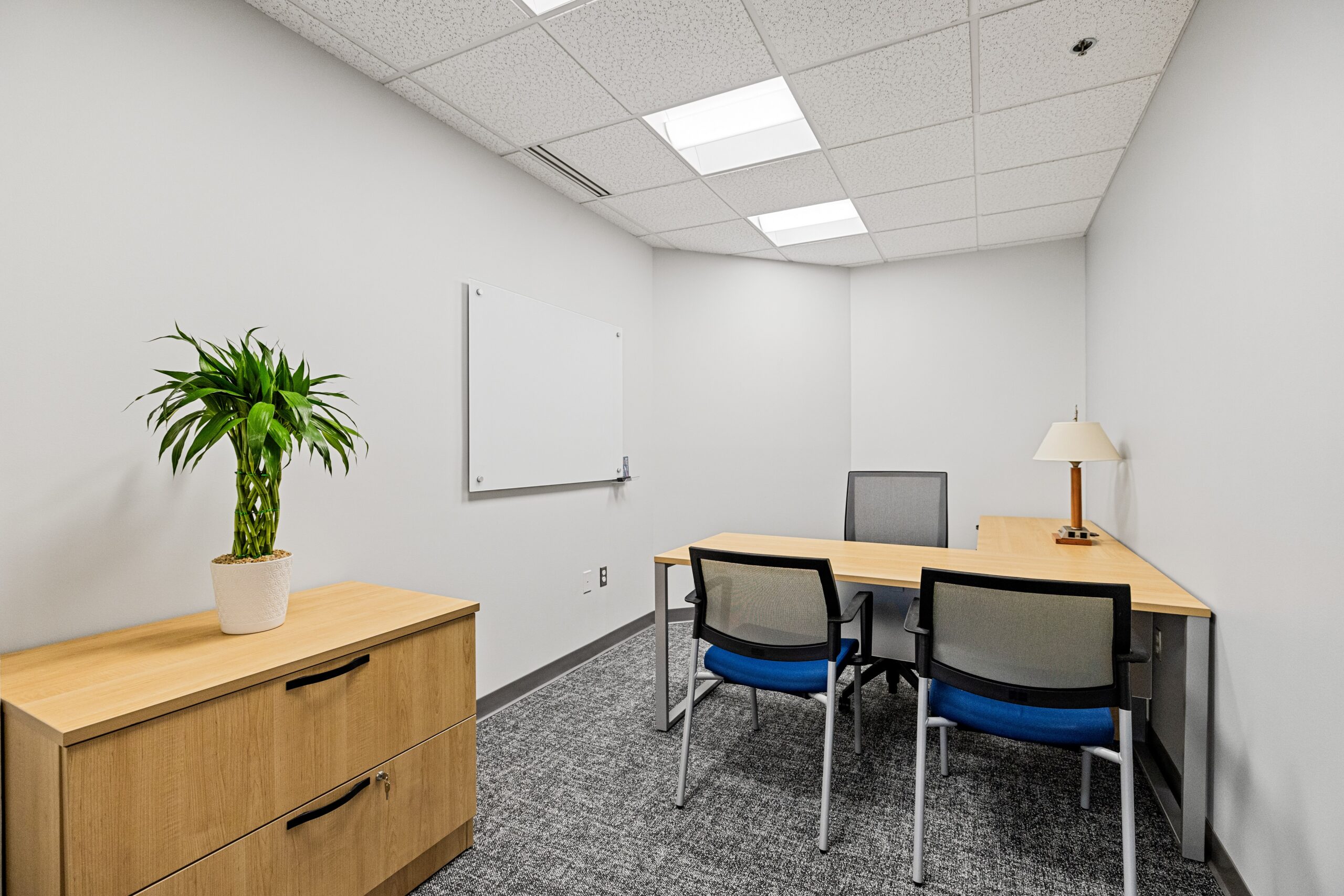 Flexible office space with modern furniture and a whiteboard for meetings and collaboration.