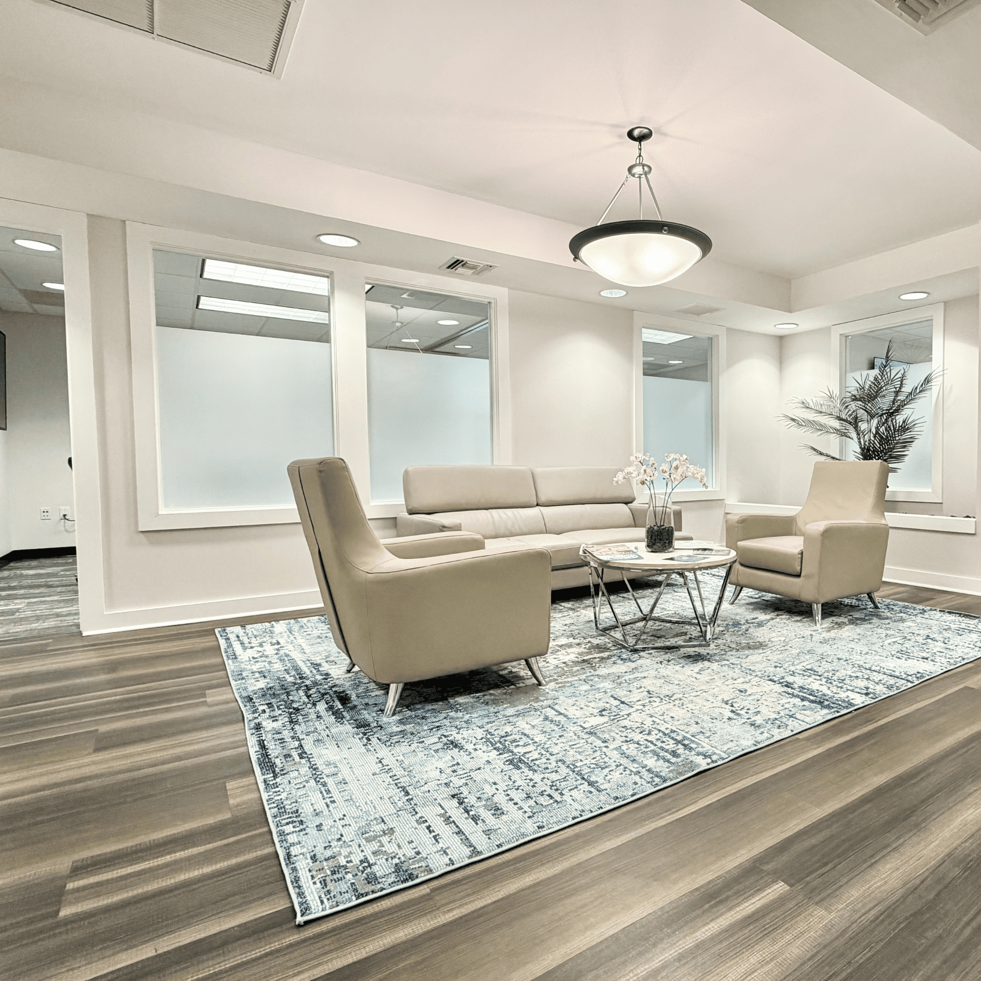 Comfortable modern office lounge with beige seating, glass walls, and stylish decor for professional.