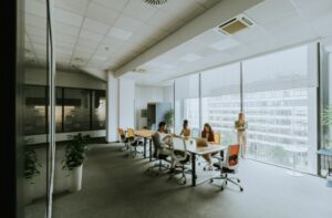 Modern corporate office meeting room with large windows and collaborative workspace.