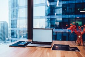 Modern office workspace with laptop, tablet, and city skyline view for flexible work solutions.