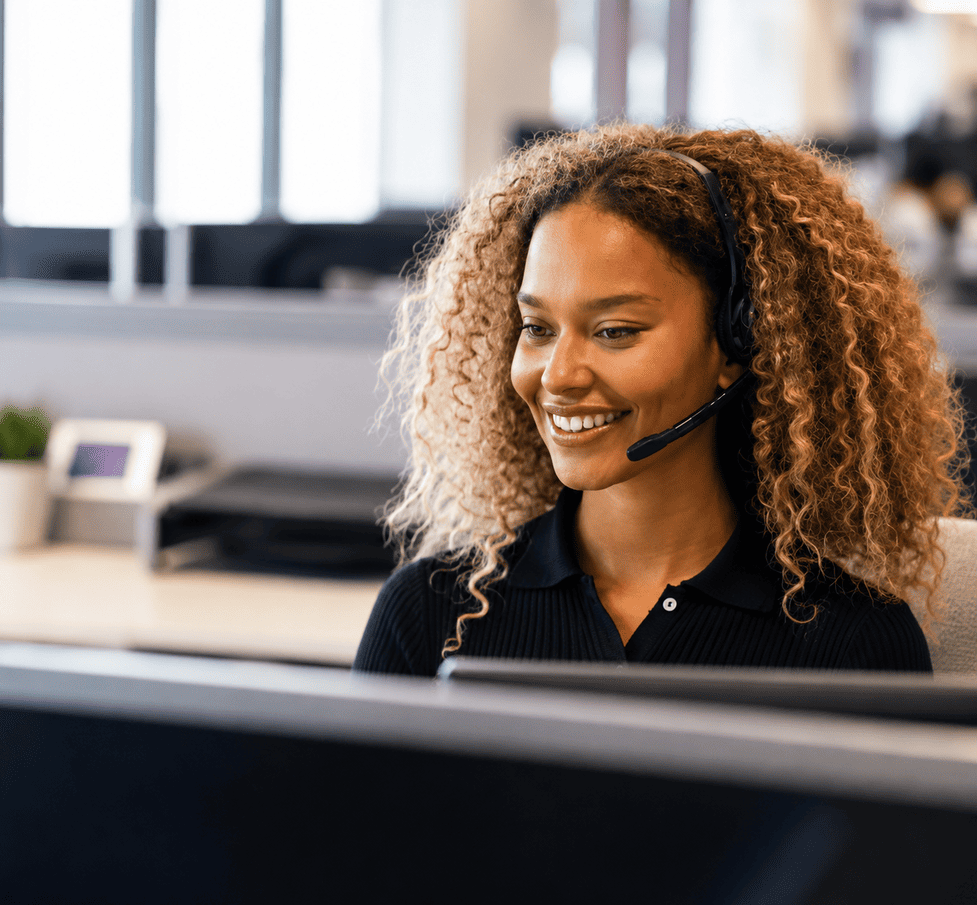 Professional customer support representative wearing a headset in a modern office.