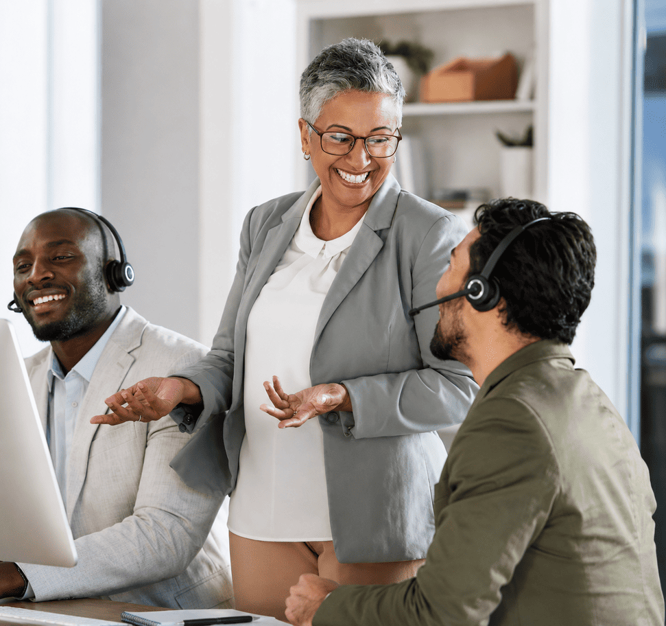 Professional support team wearing headsets while collaborating in a modern office.