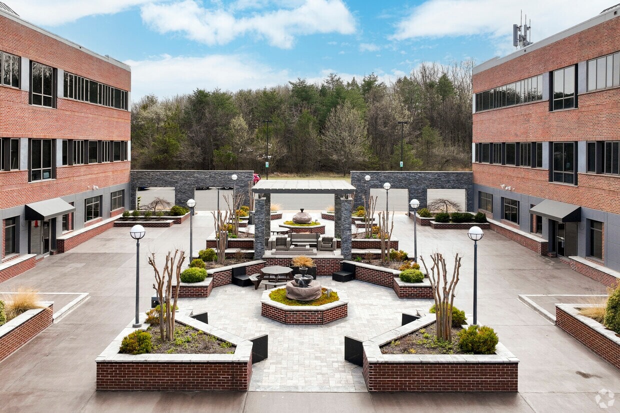 Spacious office courtyard featuring landscaped gardens, seating, and modern design elements for a pr.
