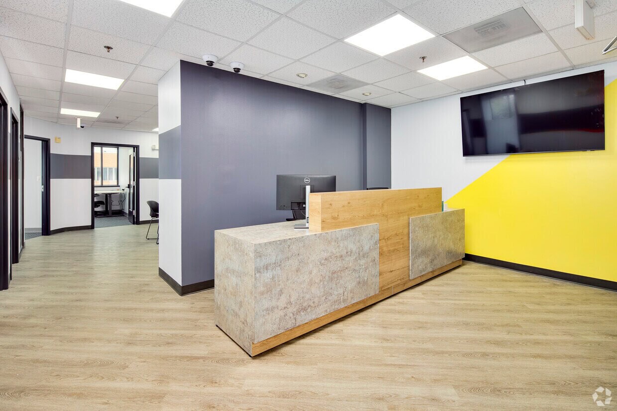 Reception desk with modern design and digital screen in a professional office environment.
