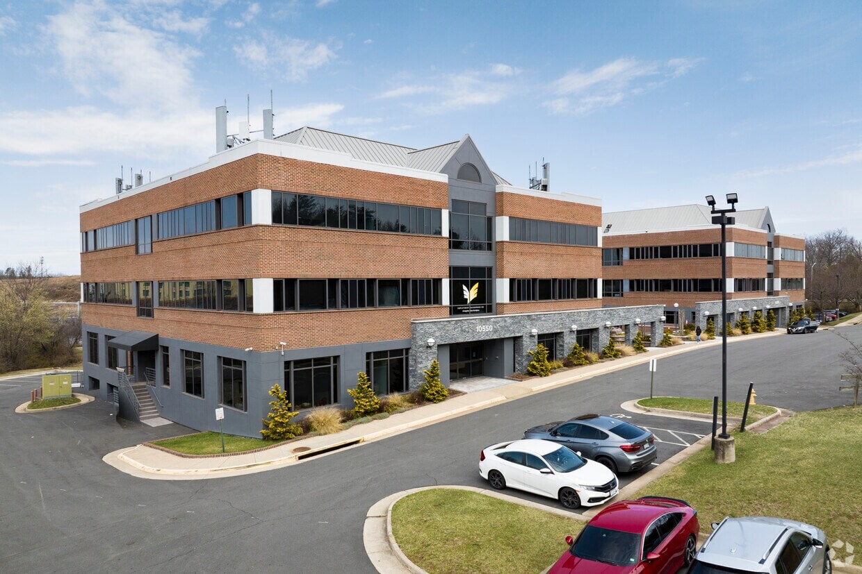 Modern office building with Intelligent Office branding and parking lot.