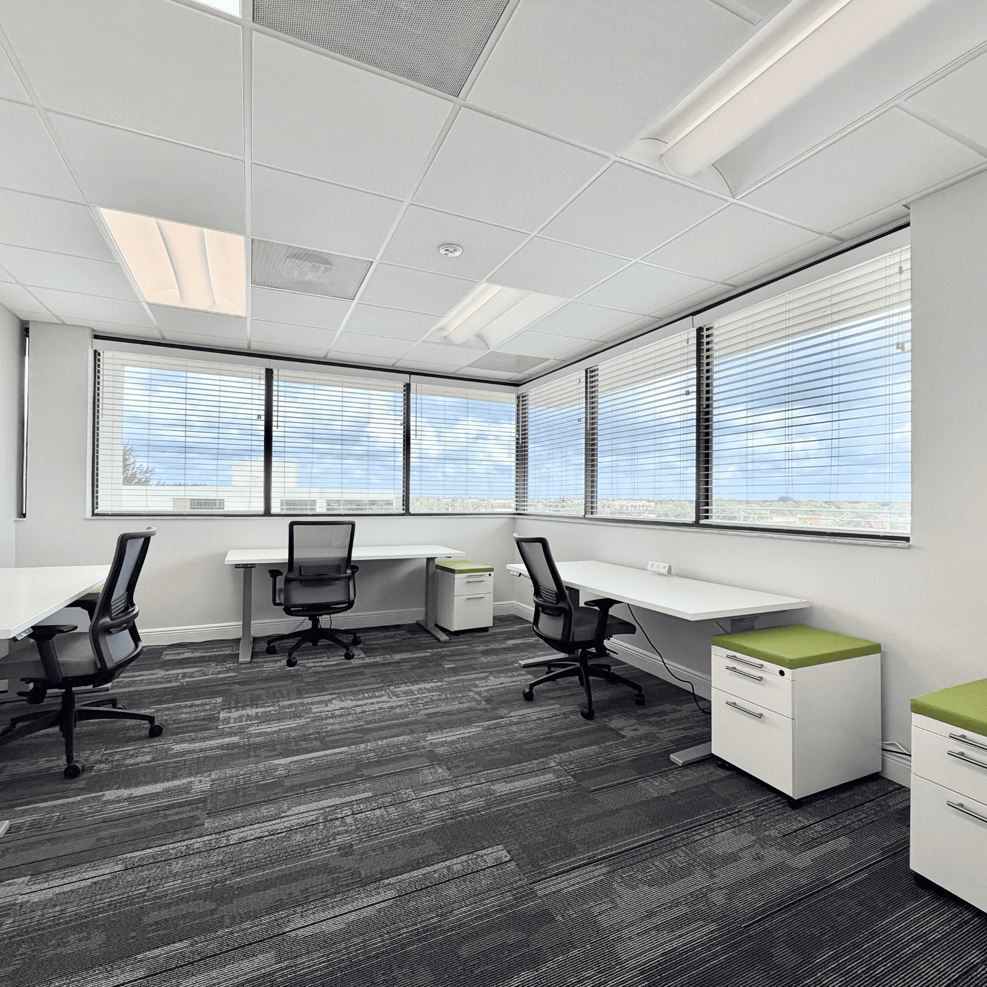 Modern office workspace with large windows and ergonomic chairs for productive work environment.
