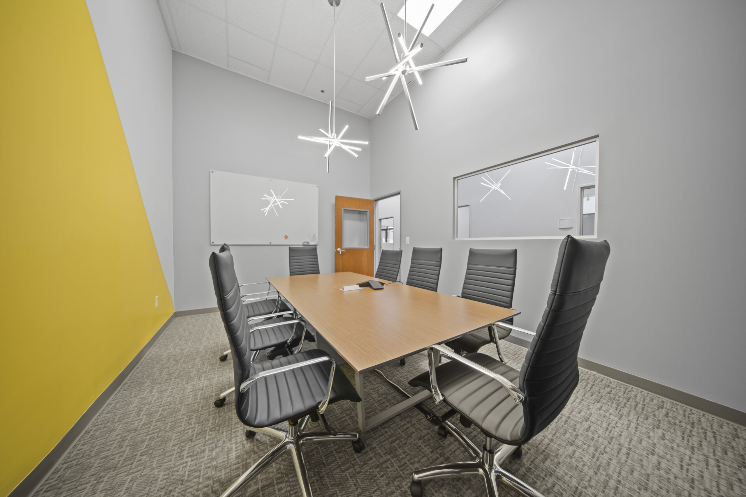 Conference room with modern furniture, black chairs, and bright lighting for meetings and collaborat.